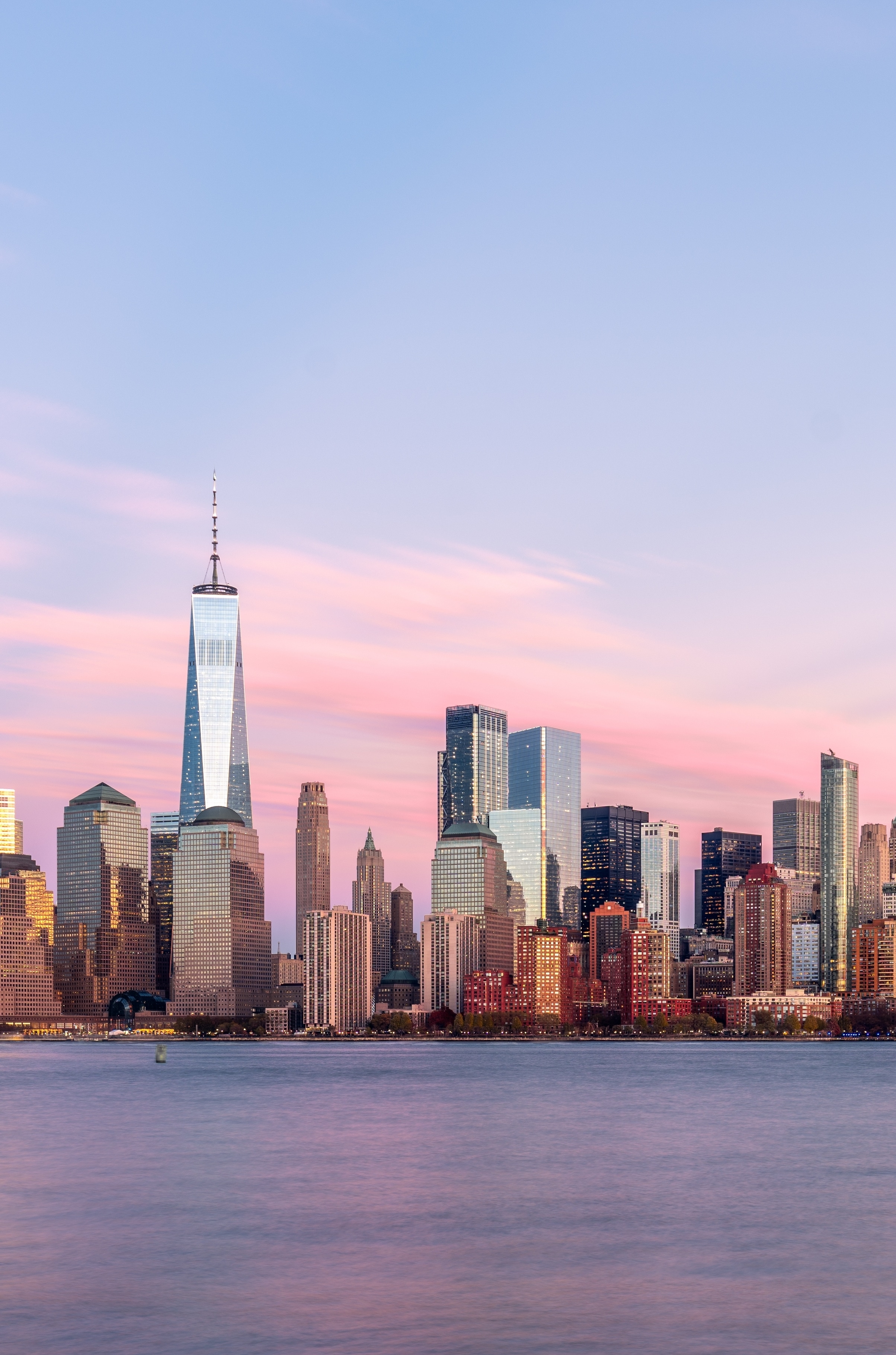 The skyline of New York City at dusk, featuring One World Trade Center 